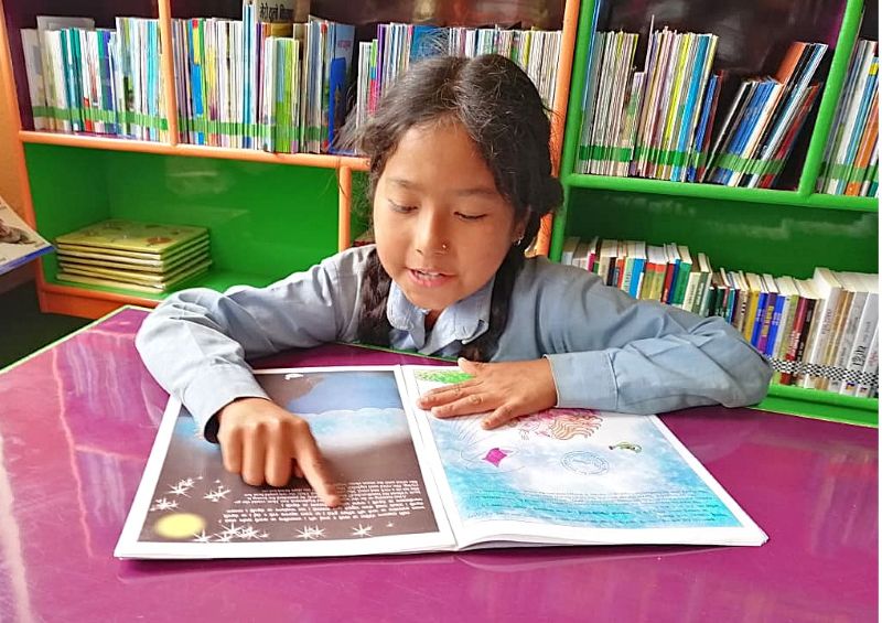 完成した図書室で本を楽しむ子どもたち